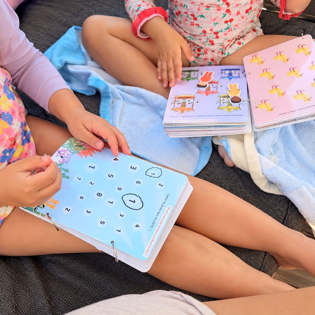 Deux enfants assises avec les livrets d'activités de petite section sur les genoux