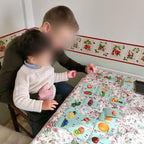 Un papa et son petit garçon jouent avec les cartes fruits sur la table de la cuisine